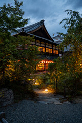 Obraz premium Traditional wooden temple building glowing at dusk in Kyoto