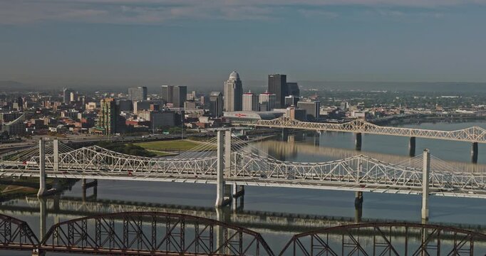Louisville Kentucky Aerial v52 reverse flyover Ohio river with freeway and pedestrian bridges over the river, views of downtown cityscape on the skyline - Shot with Inspire 3 8k - Sept 26th 2023