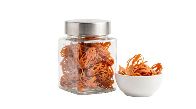 Dried mace spice in glass jar and ceramic bowl, organic whole mace blades for cooking, aromatic nutmeg aril seasoning on white background
