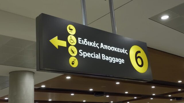 Larnaca, Cyprus airport sign directing passengers to special baggage services with accessibility symbols and a left arrow