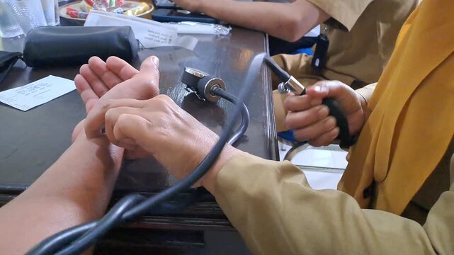 Video footage of employee health screening at an office, showing blood pressure check, blood glucose testing, and weight measurement. Corporate wellness and medical check-up stock video.