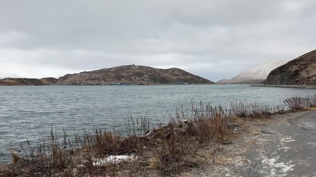 Steady shot of a quiet coastal bay and remote volcanic hills in southeast Alaska.
