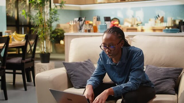 African american woman singing aloud at home and solving remote tasks, acting carefree and enjoying stress-free teleworking. Gen z freelancer being silly and multitasking, domestic life.