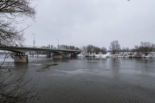 Zimowa panorama rzeki Odry w popołudniowych godzinach pochmurnego szarego zimowego dnia pełnego śniegu dnia w Zachodniej Polsce