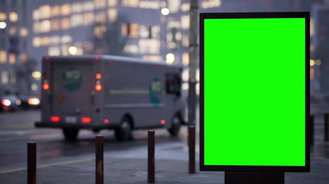Blank green screen city light billboard on a city sidewalk in soft early morning light, overcast sky. Timelapse of passing traffic with shallow depth of field and soft bokeh. Chroma key mockup for