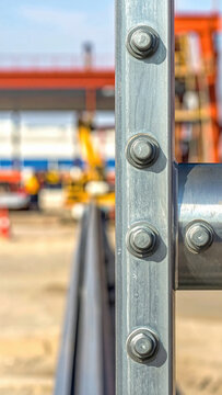 Galvanized steel beam with bolts in industrial construction site, close up detail showing metal texture and structural connection