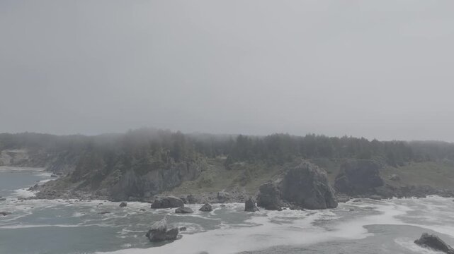 Misty coastal sea stacks rising from ocean water