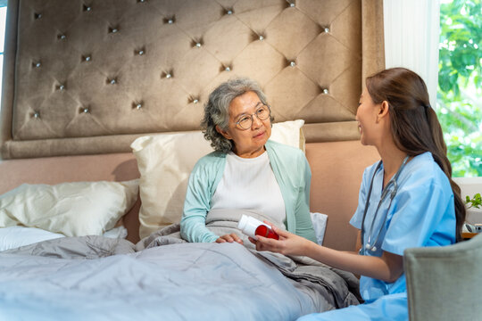 Female caregiver explaining medication instructions to senior woman patient at home, elderly healthcare support, medicine treatment consultation, home care nursing service and aging society lifestyle