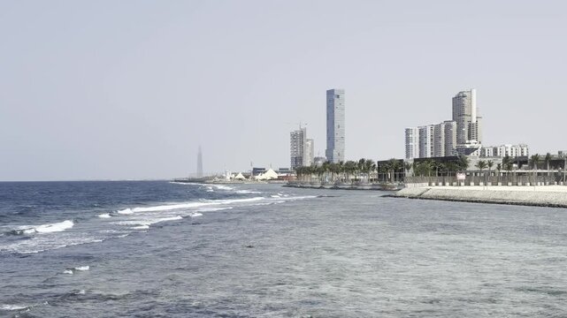 Jeddah Corniche promenade and modern skyline cityscape along the Red Sea coast with gentle waves, Saudi Arabia