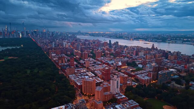 The eastern border of Central Park, rows of classic brick apartment buildings stretch out across the Upper East Side. Dramatic cloudscape covers the sky over New York City, USA at sunset.