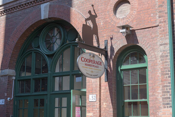 Obraz premium projecting sign outside entrance to The Cooperage Marketplace (historic barrel and cask maker) located at 52 Gristmill Lane, Distillery Historic District, Toronto