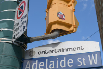Obraz premium grungy Toronto FC stickers on the back of a crossing signal in the Entertainment District at Adelaide St W