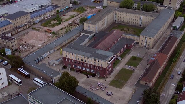 Berlin Hohenschoenhausen Memorial, a former Stasi prison, representing political persecution and communist dictatorship. Great aerial view wide orbit drone panorama
