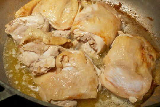 Chicken thighs browning in a pan