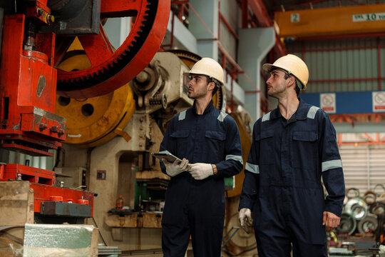 Engineers and staff are inspecting the assembly line system in a metal sheet and metal roofing manufacturing plant.