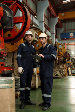 Engineers and staff are inspecting the assembly line system in a metal sheet and metal roofing manufacturing plant.