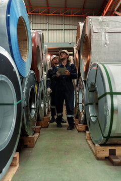 Engineers and staff are inspecting the assembly line system in a metal sheet and metal roofing manufacturing plant.