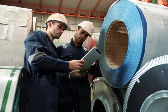 Engineers and staff are inspecting the assembly line system in a metal sheet and metal roofing manufacturing plant.
