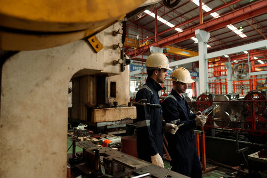 Engineers and staff are inspecting the assembly line system in a metal sheet and metal roofing manufacturing plant.