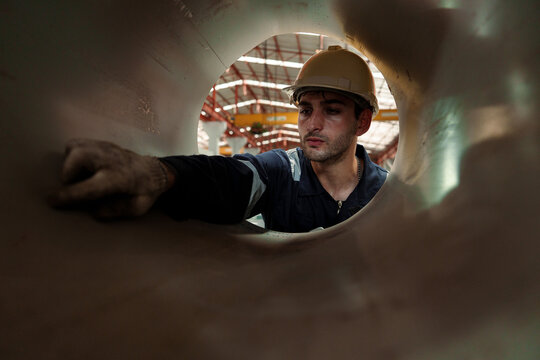 Engineers and staff are inspecting the assembly line system in a metal sheet and metal roofing manufacturing plant.