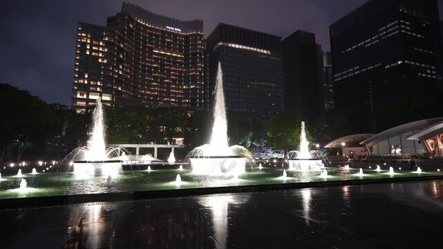 雨の夜の和田倉噴水公園と丸の内のビル群
