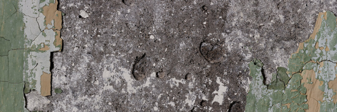 Peeling paint on the wall. Panorama of a concrete wall with old cracked flaking paint. Weathered rough painted surface with patterns of cracks and peeling. Grunge texture for wide panoramic background