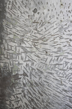 Texture of old concrete wall. Rough gray surface of concrete with a chaotic pattern of potholes and scratches. Perfect for background and design. Close-up. High resolution.