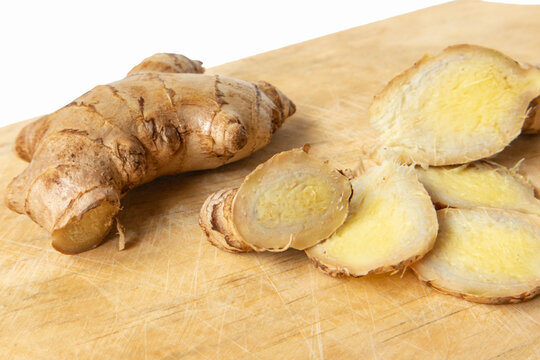 Fresh ginger root with ginger slices on a wooden board. Sliced ginger. Close-up ginger root.	