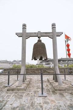 Large bronze bell mounted on stone frame at historic site