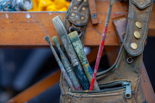  Used Paintbrushes Stored in a Canvas Apron Pocket Inside an Artist Studio