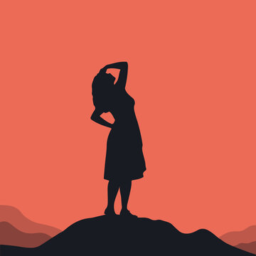 Silhouette of a woman standing on a hilltop against warm sunset background with silhouette standing lifestyle serenity