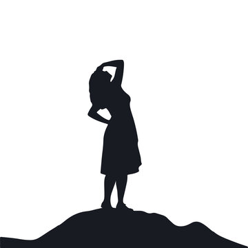 Silhouette of a woman standing on a hilltop against warm sunset background with silhouette standing lifestyle serenity