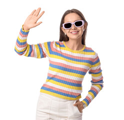 Friendly greeting and positive communication, young woman waving hand with smile wearing colorful striped sweater and sunglasses isolated on white background © Pixel-Shot