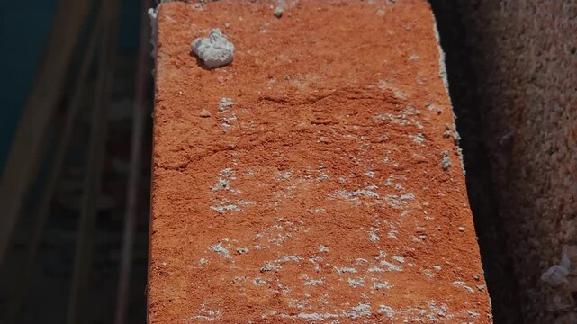 Rough texture of unfinished red clay brick wall with mortar joints