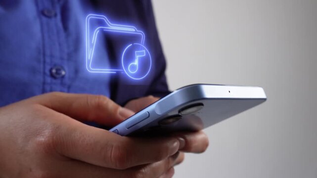Music files. Businesswoman holding a smartphone with a virtual icon of a folder featuring a musical note.