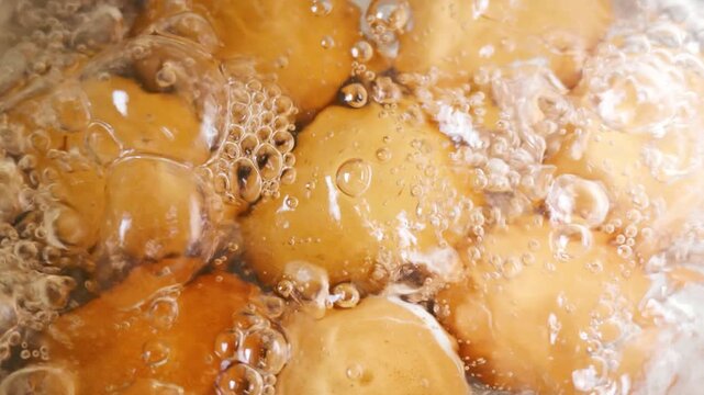 Slow Motion of Boiling Hot Brown Eggs in Pot with Rolling Water Bubbles