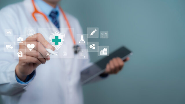 Medical professional is holding a tablet displaying digital healthcare icons, representing modern medical technology, health insurance information