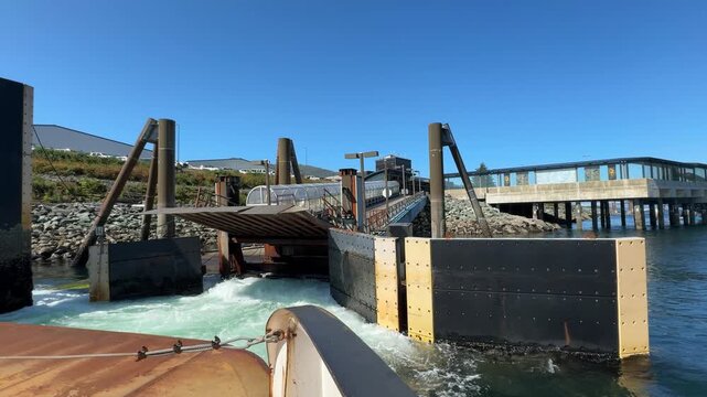 Ferry boat hull approaching loading ramp with foaming churning waters in Gravina Island, Ketchikan,, Alaska.