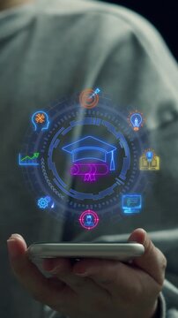 Close-up vertical shot of hand holding smartphone with glowing graduation cap and learning icons. Online education e-learning platform, academic degree certification, and university study concept.