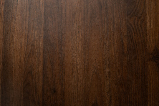 Dark brown walnut wood texture background with natural grain pattern