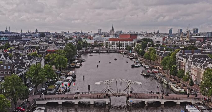 Amsterdam Netherlands Aerial v39 low level flying over amstel river across skinny and blue bridge capturing historic downtown cityscape at jodenbuurt neighbourhood - August 2021