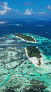 Stunning wide drone view of sunny tropical paradise island with crystal clear turquoise water. Ideal backdrop scene for summer holiday, spa, and wellness videos.