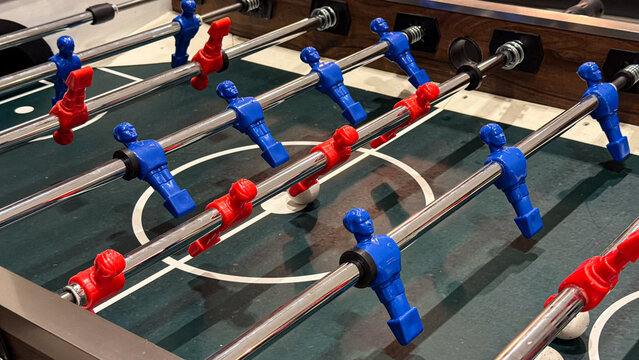 Table football game with red and blue players in a modern indoor recreation room, leisure, entertainment and competitive game concept.