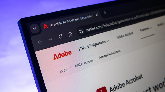 Adobe website featuring Acrobat AI Assistant page on laptop screen.