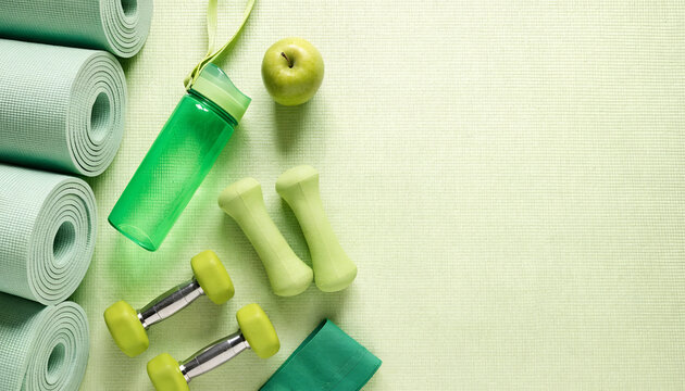 Healthy Lifestyle and Fitness Concept &mdash; Green Dumbbells, Water Bottle, Yoga Mats and Fresh Apple