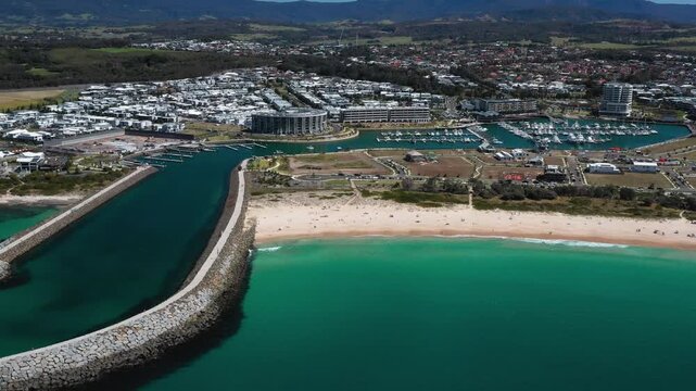 Zoom out view of the Shell Cove breakwater and turquoise blue entrance leading to the scenic Shellharbour Marina and beaches, situated on the Illawarra South Coast of New South Wales, Australia.