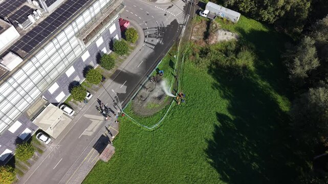 Top-down aerial view of participants moving through muddy water while powerful water jets create an additional obstacle.