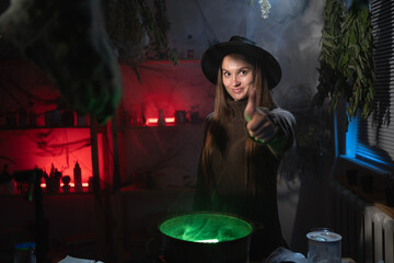 realistic witch brewing a potion in cauldron pointing thumb up like gesture. Blend of everyday life with traditional witchcraft, magic and mystical atmosphere © Andrii Lysenko