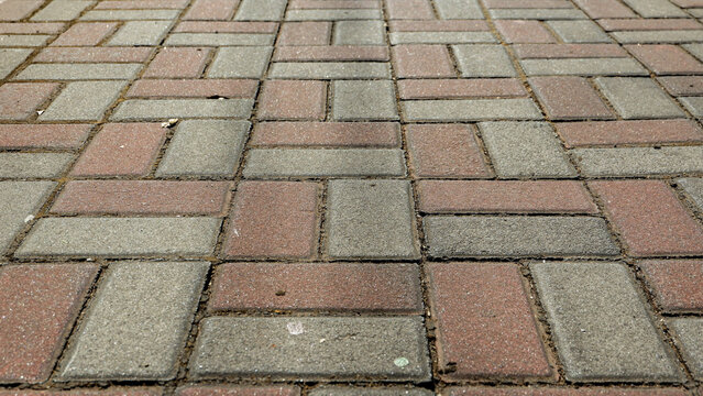 Textured interlocking paving stone surface background showing a clean geometric pattern on an outdoor path.