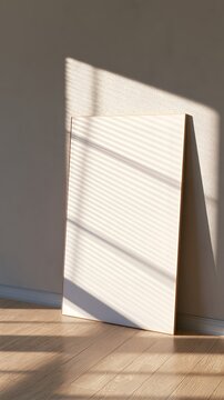 Blank vertical poster mockup leaning against plaster wall on wood floor